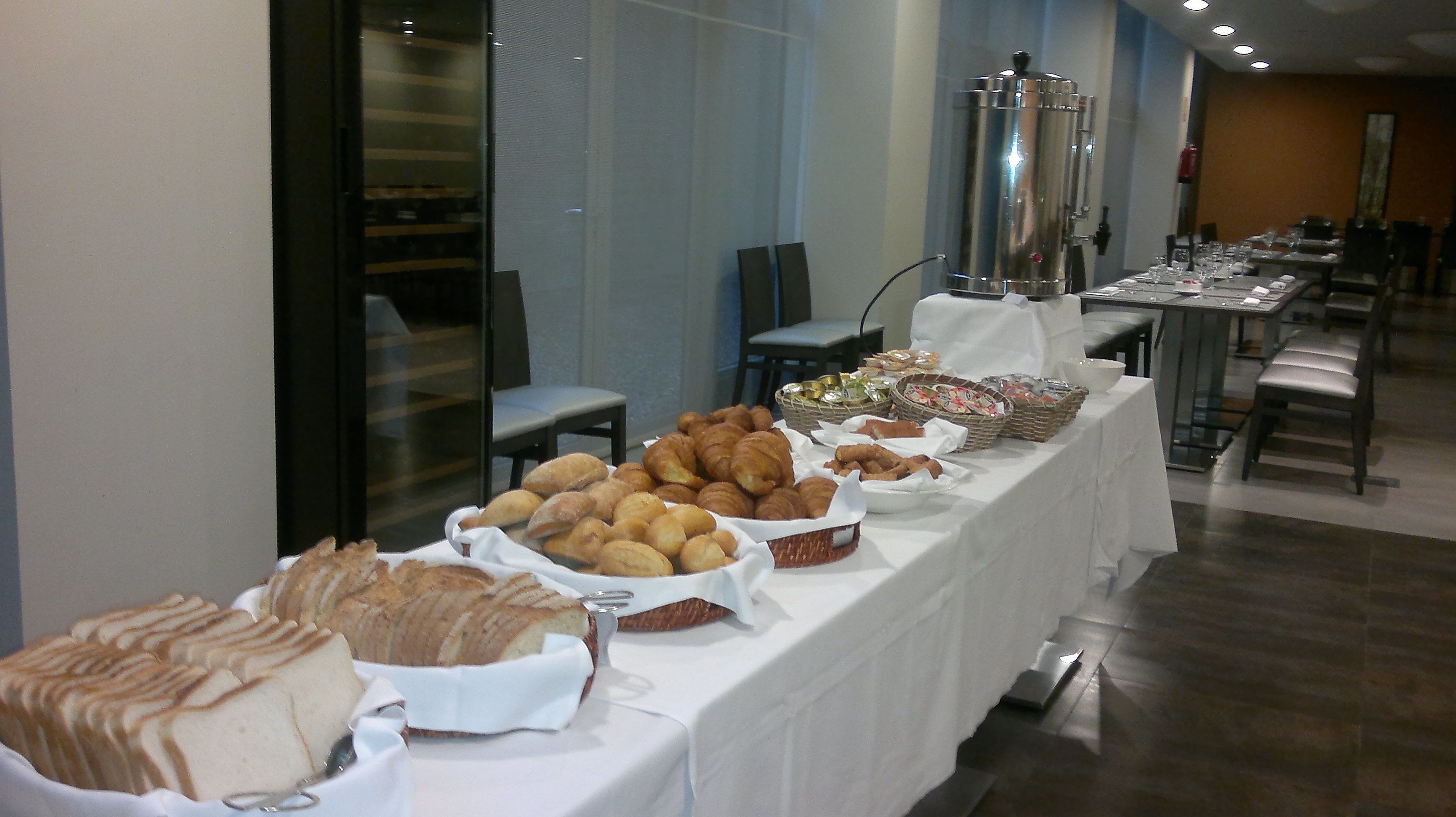 A buffet table with various baked goods and pastries.
