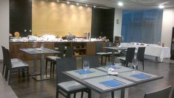 A restaurant with multiple tables set for dining, a bar area, and a counter with various items.