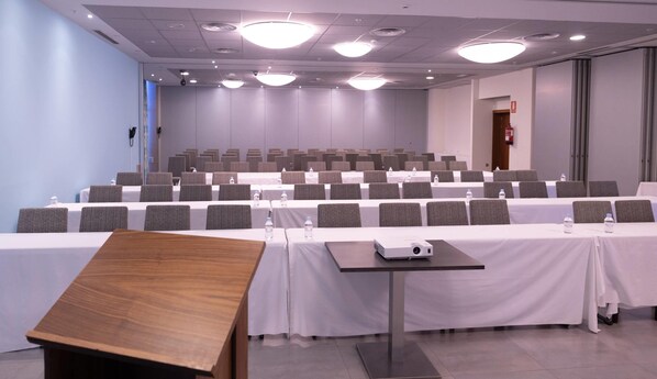 A conference room with rows of tables, chairs, and a projector. - Hotel Ciudad de Ponferrada, Ascend Hotel Collection (Ponferrada)