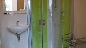 A modern bathroom with a glass shower enclosure, a sink, and a towel rack.