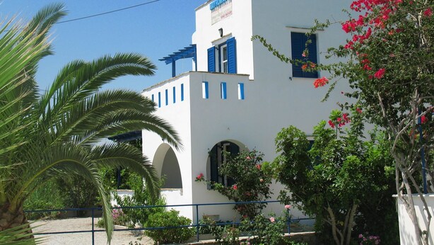 Un bâtiment blanc avec des volets bleus et une enseigne sur laquelle on peut lire « MAYOMAYO'S ».