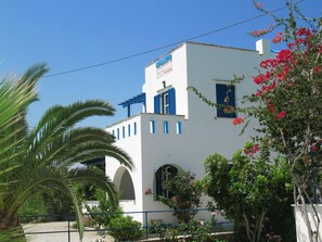 Un edificio bianco con persiane blu e un cartello con su scritto "MAYOMAYO'S".