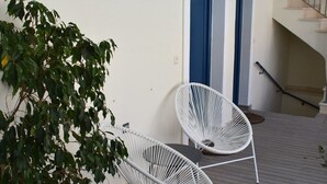 A modern indoor seating area with two white chairs and a potted plant. - Christina Studios & Apartments (Parga)