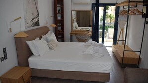 A modern bedroom with a large bed, bedside tables, a wardrobe, and a balcony with a view. - Christina Studios & Apartments (Parga)