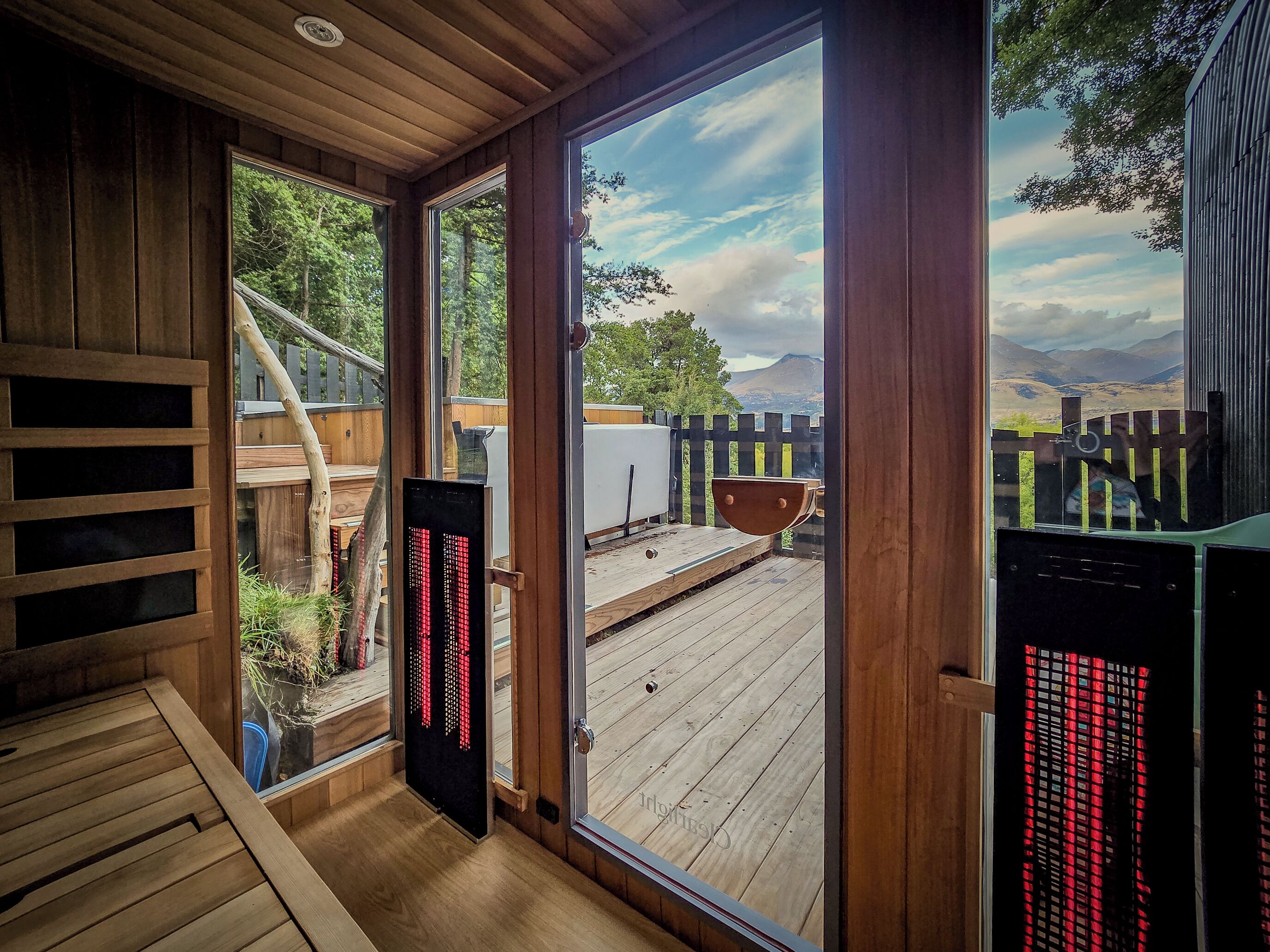 Une terrasse en bois offrant une vue sur un paysage montagneux.