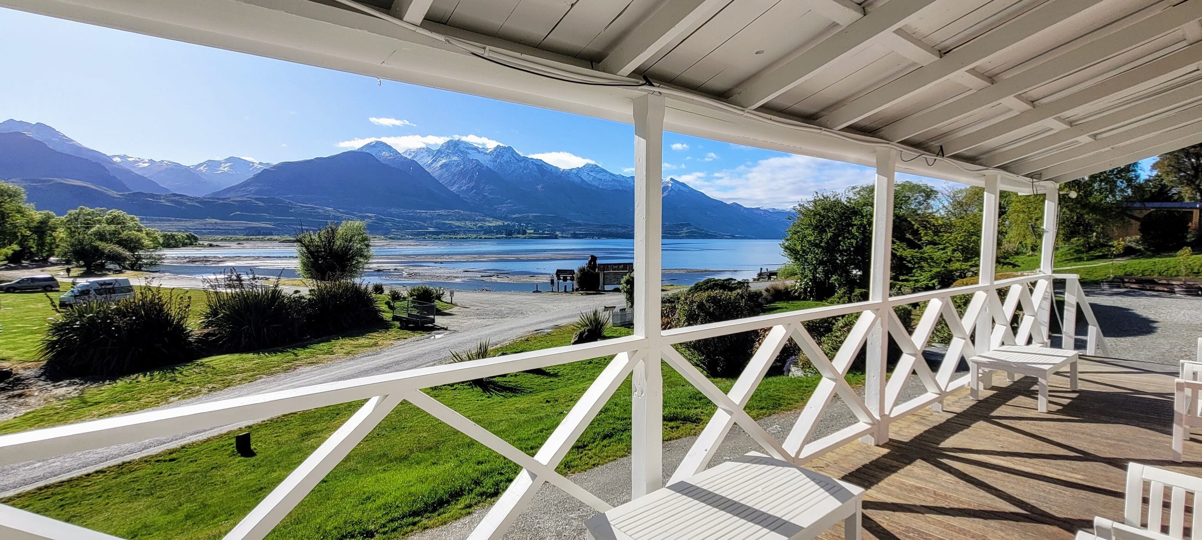 A covered outdoor area with a view of mountains and a lake.