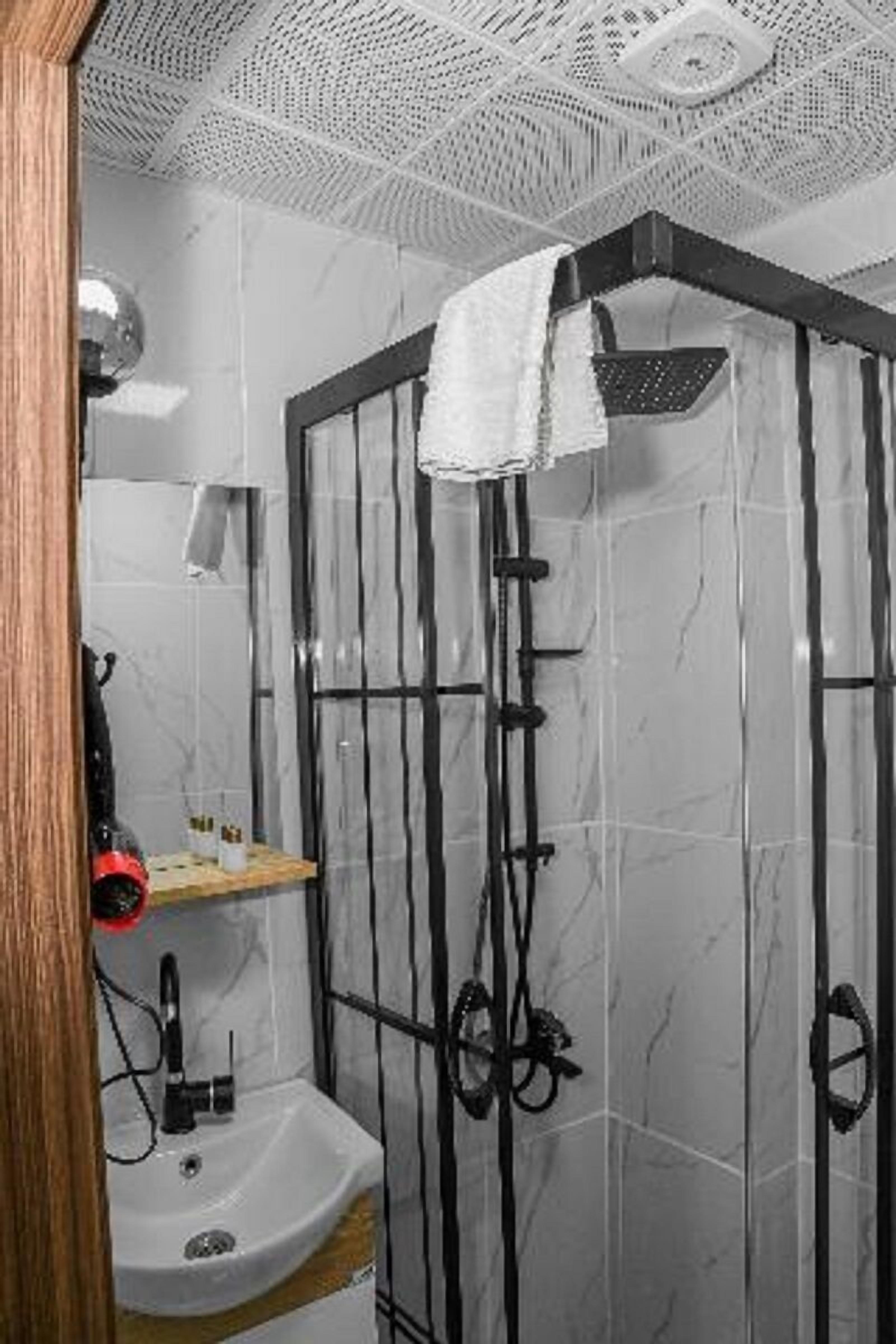 Ein Badezimmer mit Dusche, Waschbecken und Handtuchhalter.