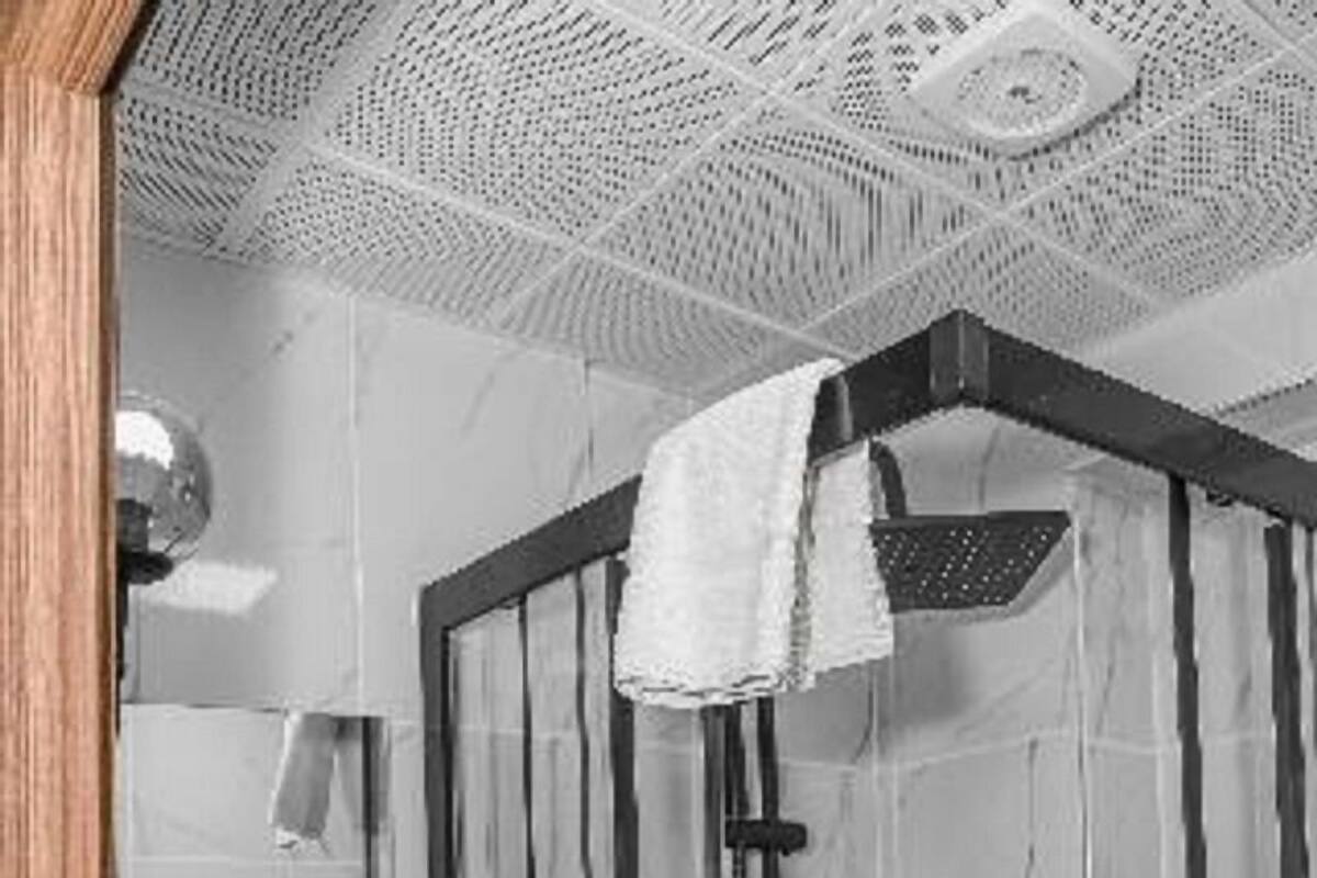 A bathroom with a shower, sink, and towel rack.