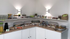 Un bufé de desayuno con diversos alimentos y bebidas en estantes y mostradores.