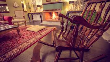 A cozy living room with a fireplace, a rocking chair, and a coffee table.