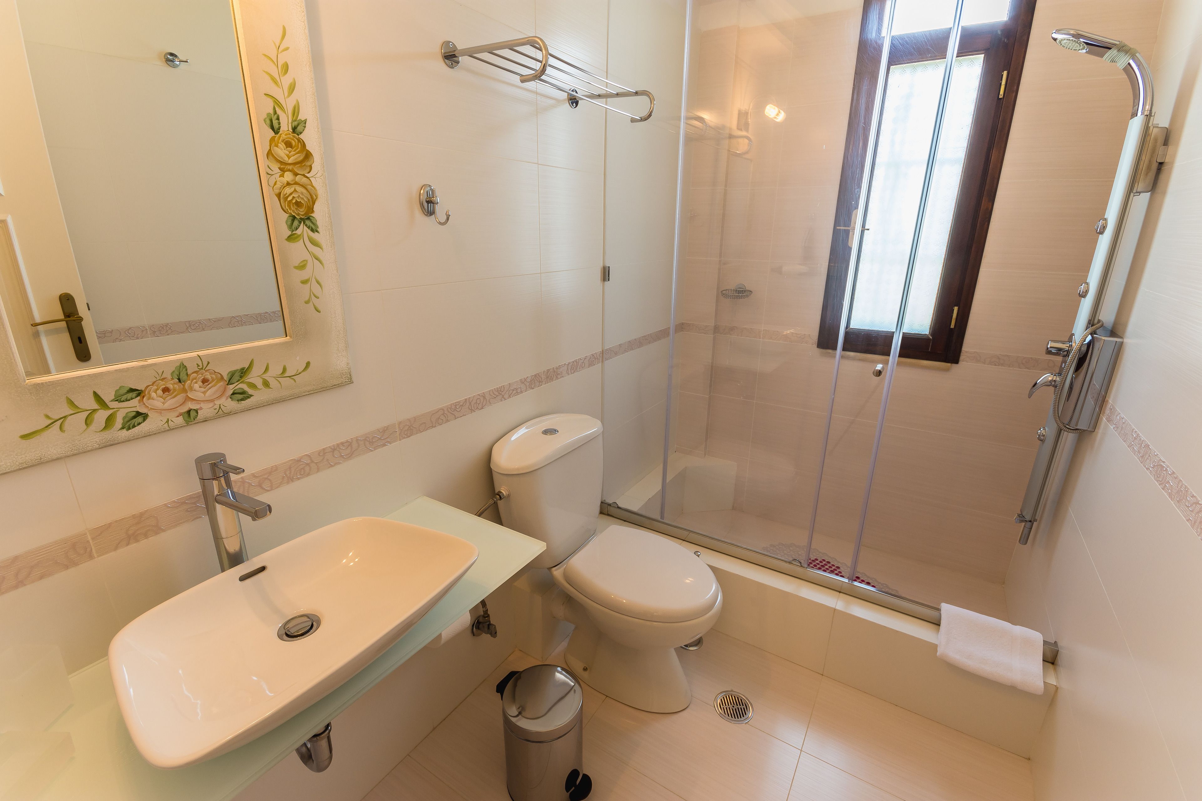 A bathroom with a sink, toilet, and glass-enclosed shower.