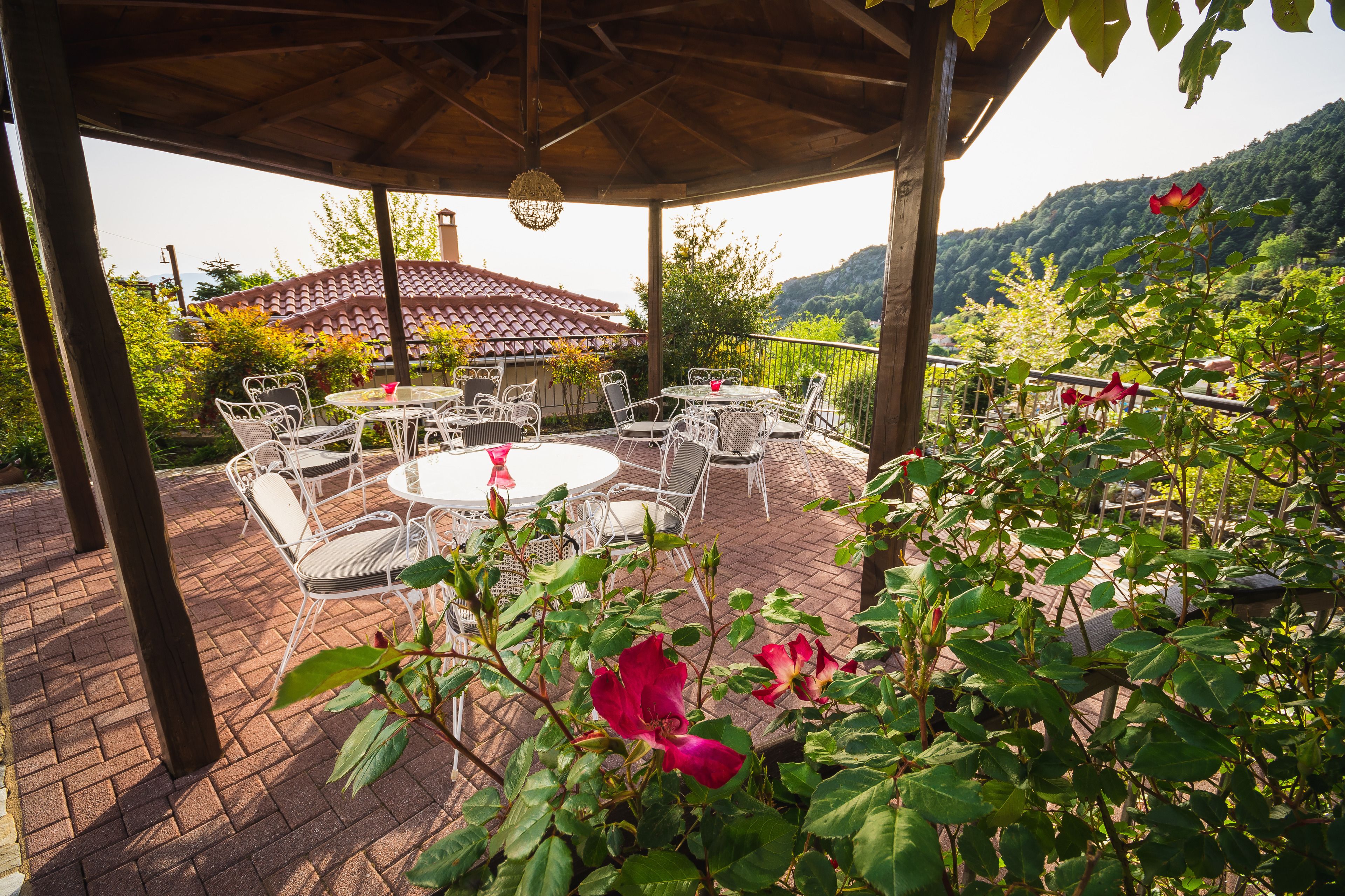 A covered patio with outdoor furniture and a view of a mountain.