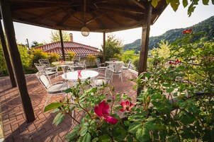 Un patio techado con mobiliario exterior y vistas a la montaña.