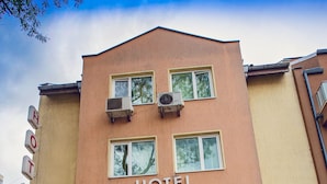 A hotel named "HOTEL COLOR" with a beige facade, multiple windows, and a flag. - Hotel Color (Varna)