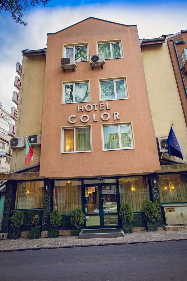 A hotel named "HOTEL COLOR" with a beige facade, multiple windows, and a flag. - Hotel Color (Varna)