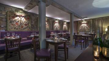 Un restaurante con cabinas, mesas y una zona de bar.