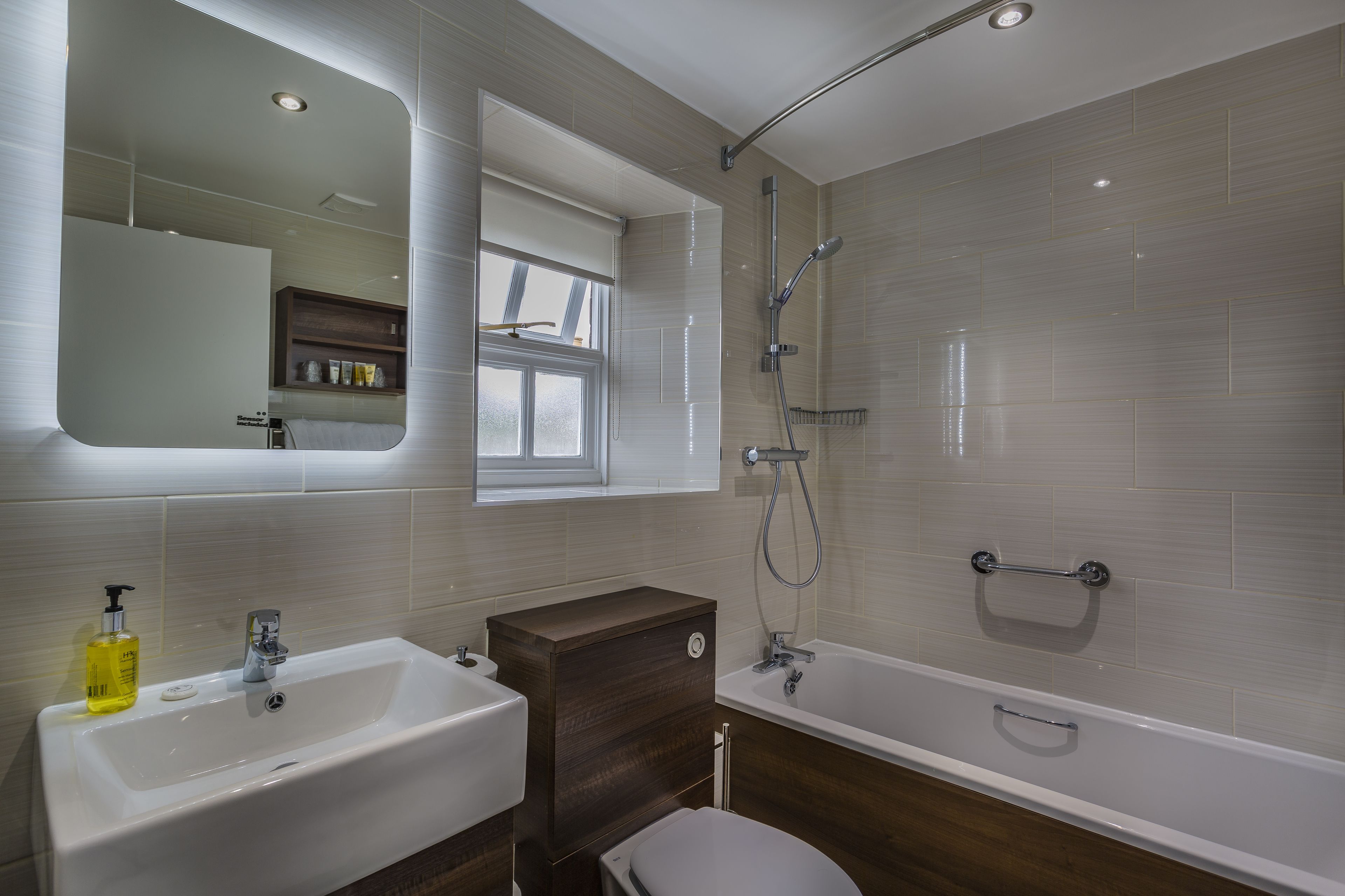 Un baño moderno con lavamanos, inodoro y bañera.