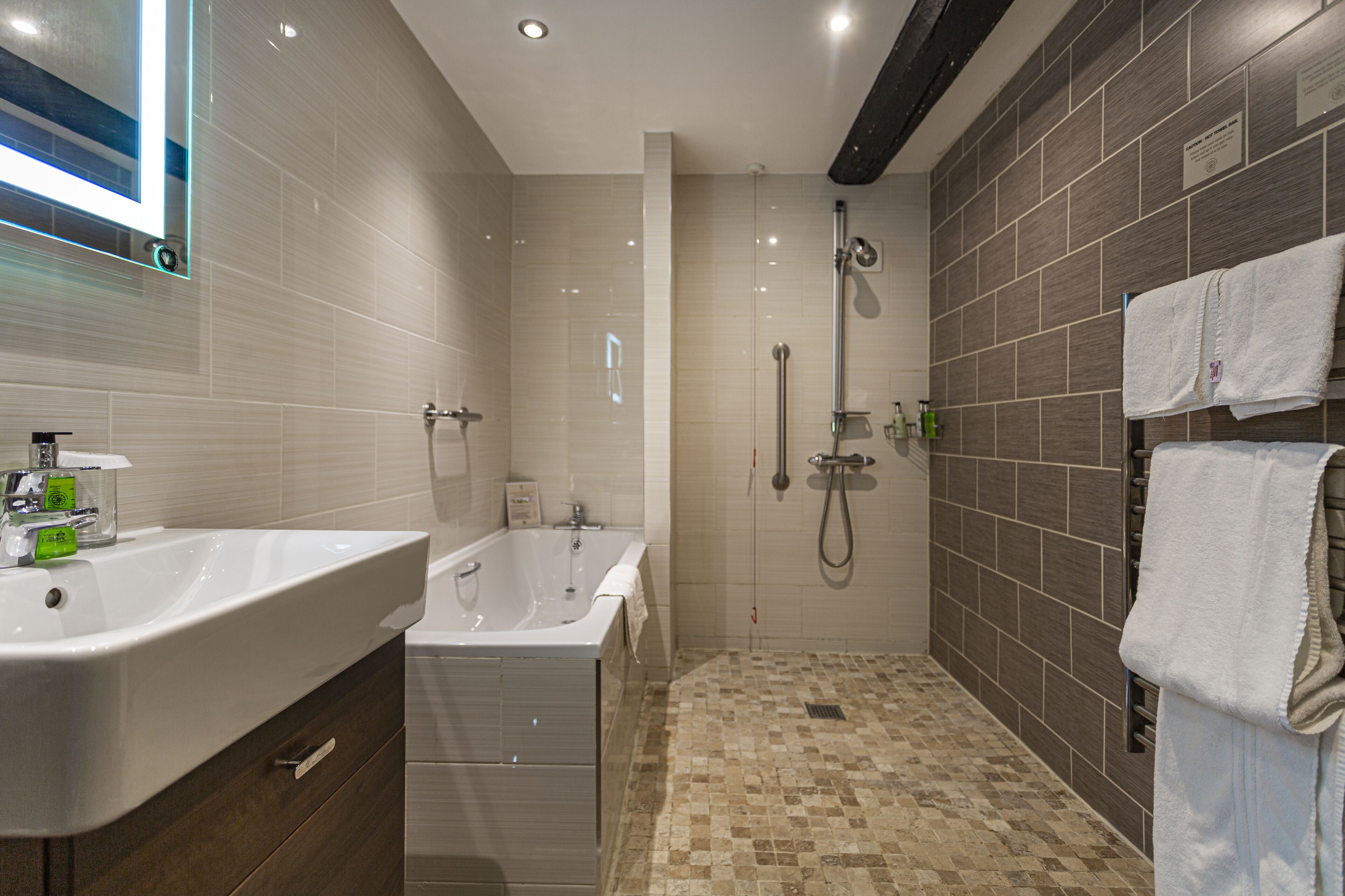 A modern bathroom with a large sink, a bathtub, and a shower area.