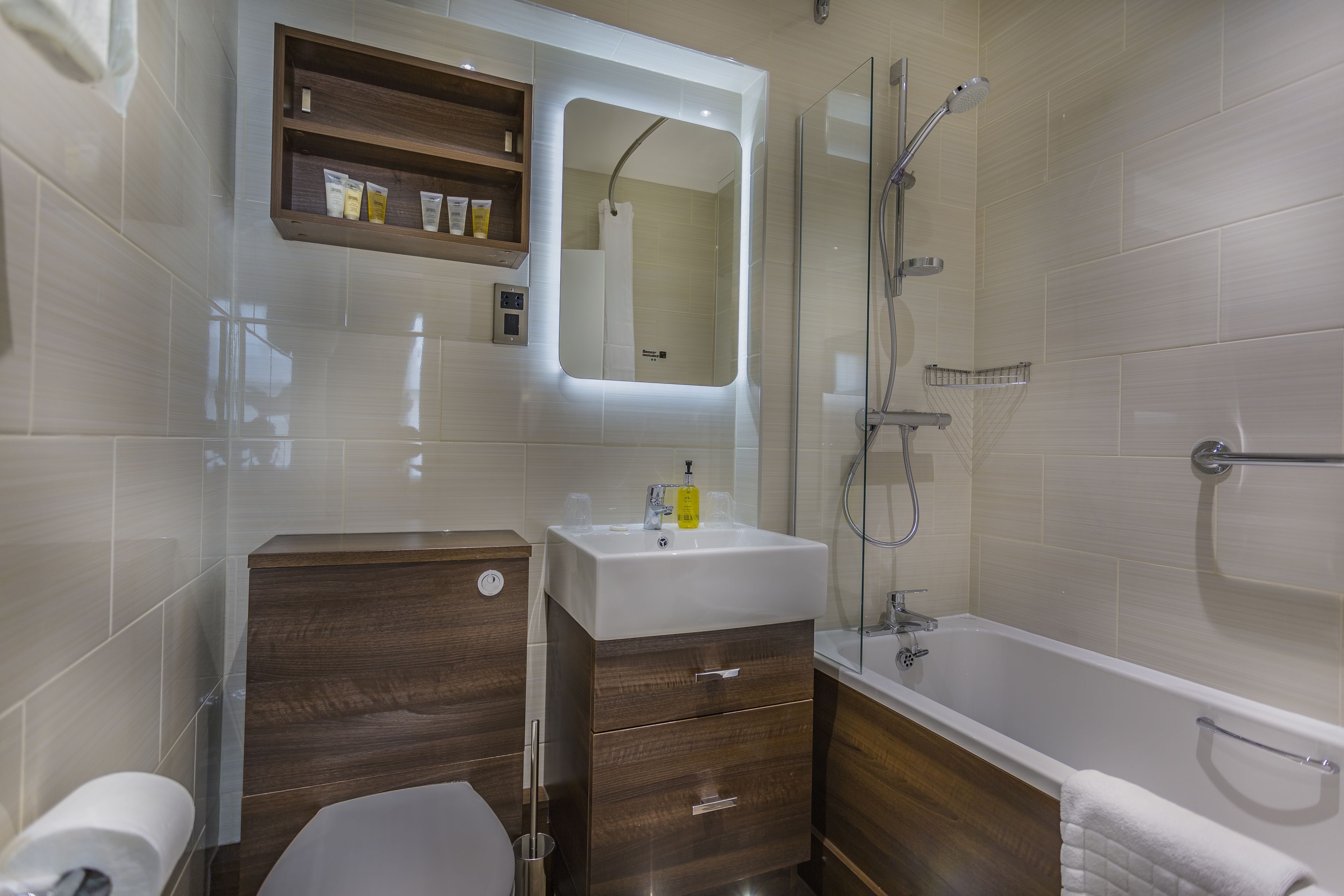 A modern bathroom with a toilet, sink, and bathtub.