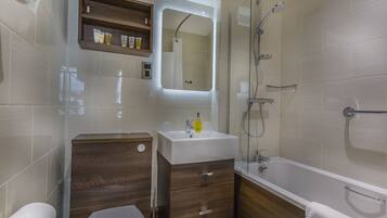 A modern bathroom with a toilet, sink, and bathtub.