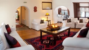 Ein gemütliches Wohnzimmer mit weißen Sofas, einem Couchtisch mit dekorativer Dekoration und einem gemusterten Teppich.