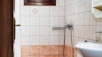 A bathroom with a toilet, a shower, and a sink.