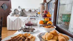 Ein Frühstücksbuffet mit verschiedenen Speisen und Blick ins Freie.