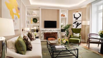A modern living room with a sofa, coffee table, fireplace, television, and decorative items.