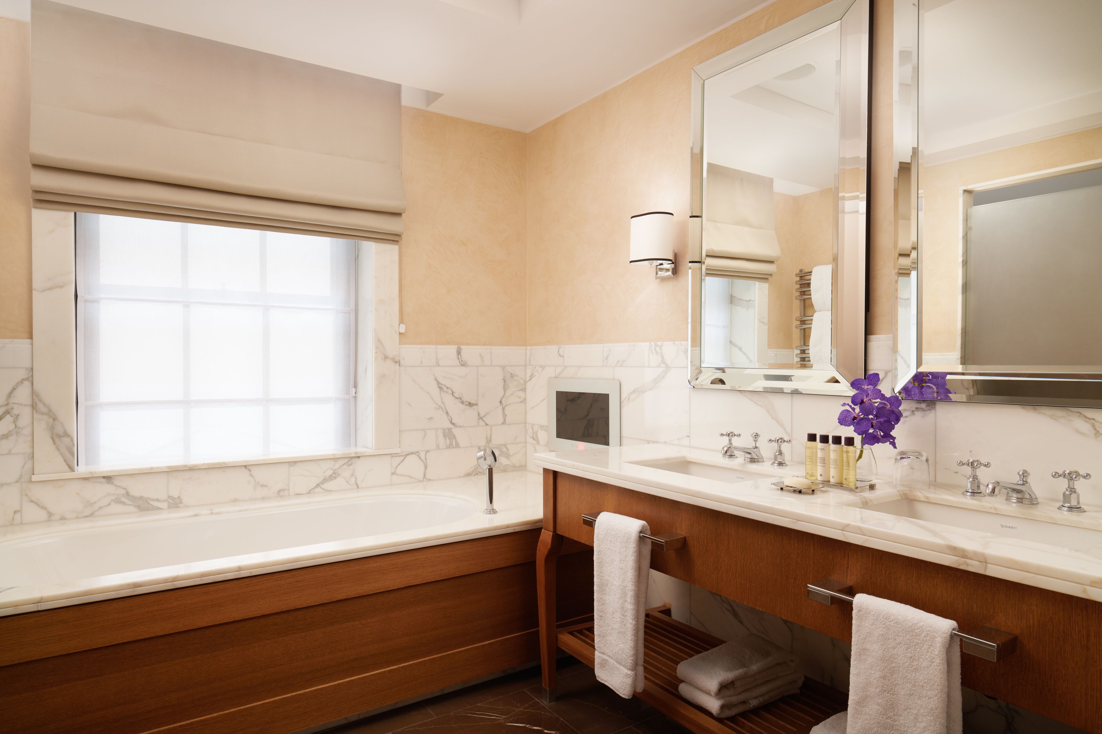 Une salle de bain moderne avec un lavabo en marbre, un meuble-lavabo en bois et un grand miroir.