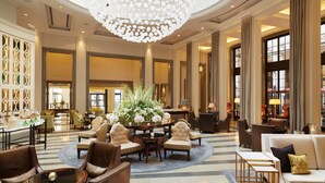 A spacious lobby with a large chandelier, seating areas, and a decorative centerpiece. - Corinthia London (London)