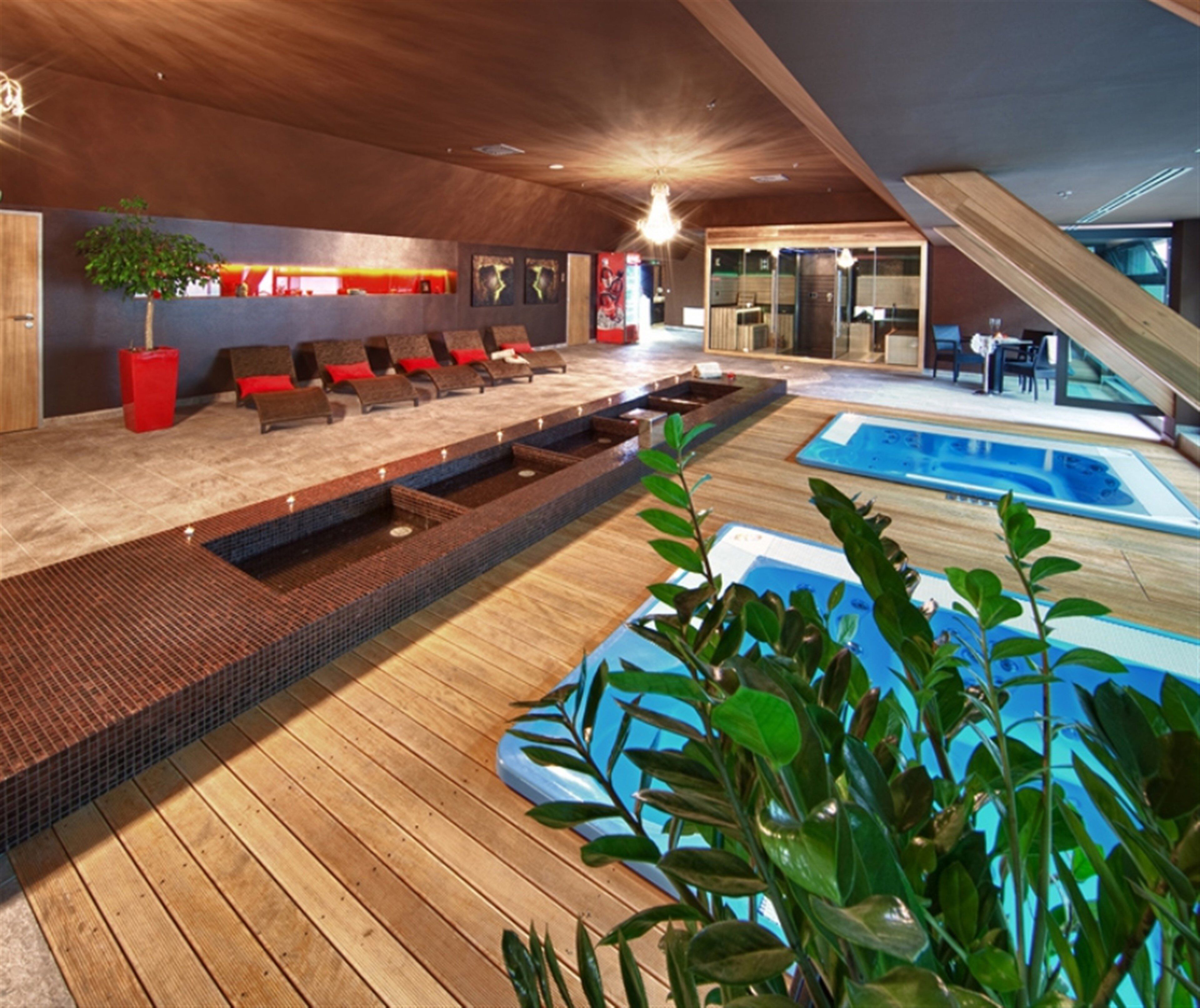 Un área interior de piscina moderna con asientos y una piscina pequeña.