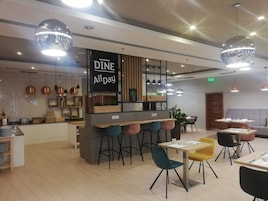 Un café moderno con barra, diferentes disposiciones de asientos e iluminación colgante.