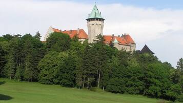 A castle with a prominent tower and a red-roofed building.