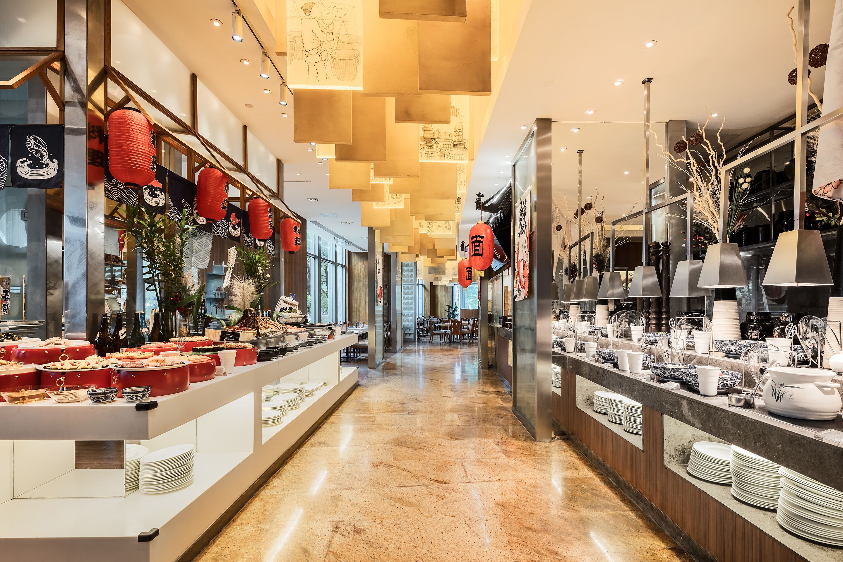 A modern hotel lobby with a long reception desk, red lanterns, and a variety of dining ware displayed.