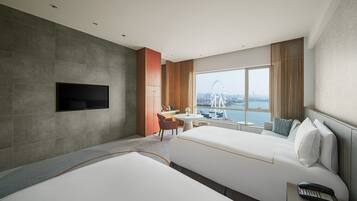 Habitación de hotel moderna con una cama grande, un escritorio y un televisor montado en la pared.