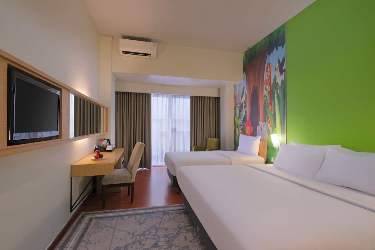 Ein Hotelzimmer mit einem großen Bett, einem Schreibtisch mit Stuhl, einem Fernseher und einem Bild an der Wand.