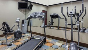 Un gimnasio con cinta de correr, elíptica y escaladora.
