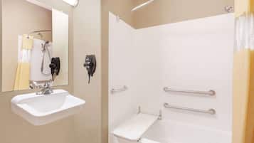 Un baño con lavamanos blanco, espejo y ducha.