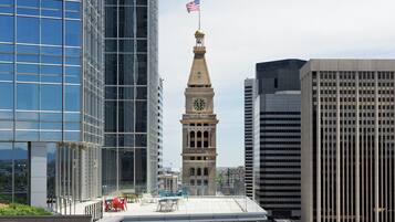 A modern cityscape with a historic clock tower, surrounded by high-rise buildings.