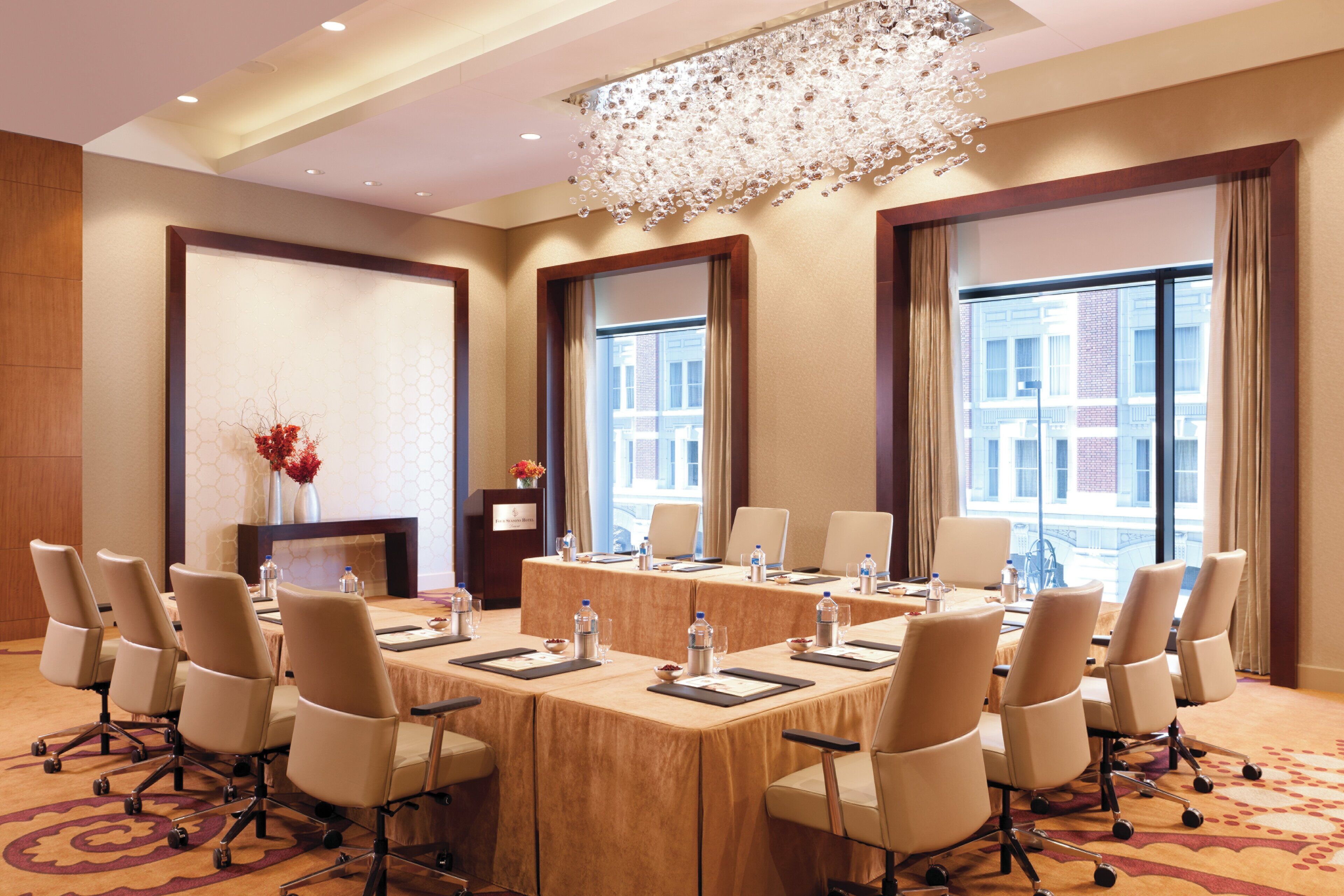 A conference room with a long table, chairs, and a chandelier.