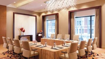A conference room with a long table, chairs, and a chandelier.