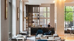 Un interior moderno con una zona de bar, asientos y vistas al exterior.