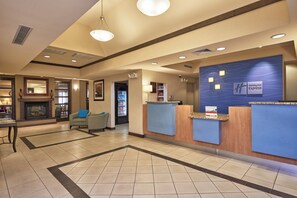 A hotel lobby with a reception desk, seating area, and a fireplace. - Holiday Inn Express & Suites El Paso Airport Area by IHG (El Paso)
