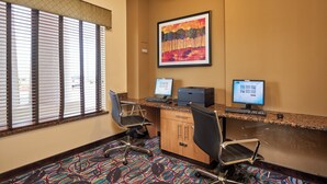 A hotel room with a desk, two computers, a chair, and a painting on the wall. - Holiday Inn Express & Suites El Paso Airport Area by IHG (El Paso)