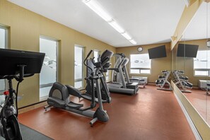 A gym with exercise equipment, a mirror, and a clock on the wall. - Best Western Plus St. Albert (St. Albert)