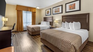 Ein Hotelzimmer mit zwei Betten, einem Schreibtisch und einem Fernseher.