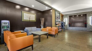 Eine Lobby mit Sitzgelegenheiten, einem Geldautomaten und einem Kamin.