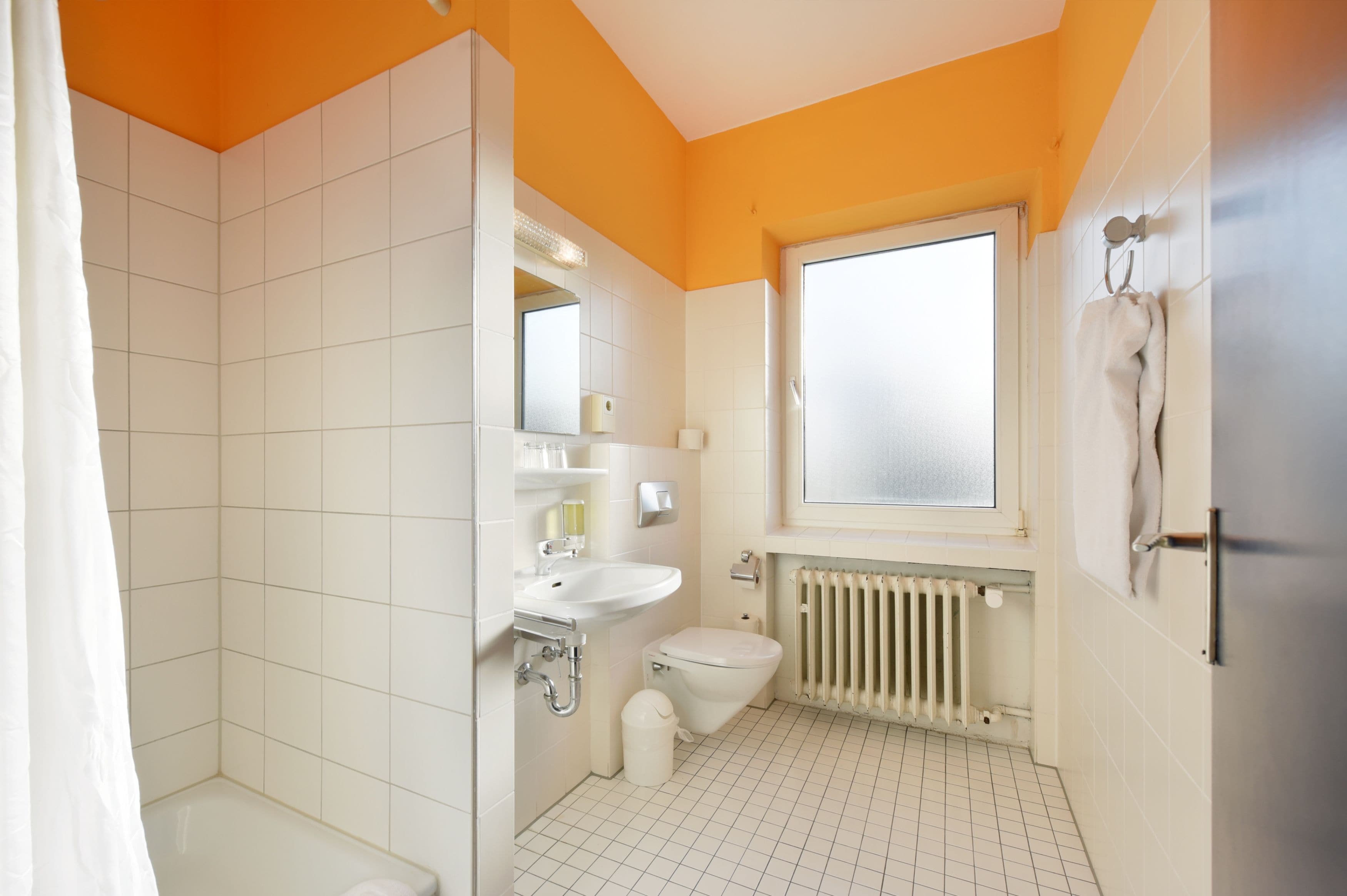 A bathroom with a toilet, sink, and shower area.