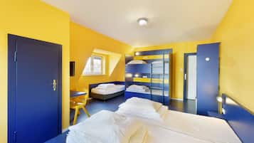 A room with two beds, a desk, a chair, and a window.