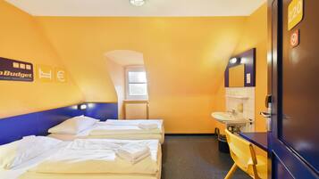 A hotel room with two beds, a bathroom, and a view of the outside.